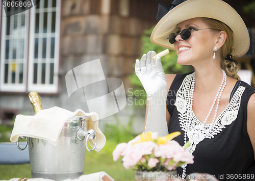 Image of Twenties Dressed Woman Eating and Drinking Champagne At Outdoor 