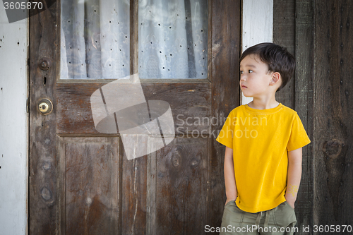 Image of Melancholy Mixed Race Boy Standing In Front of Door