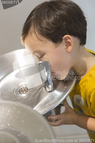 Image of Mixed Race Boy Drinking From the Water Fountain