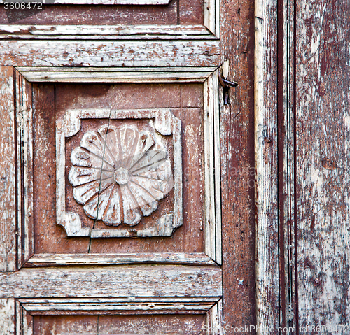Image of nail dirty stripped paint in the brown wood door and rusty  yell