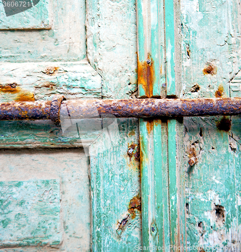 Image of rusty metal     nail dirty stripped paint in the blue green