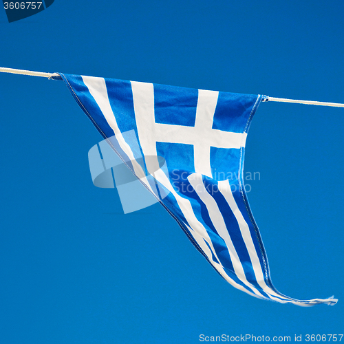 Image of waving greece flag in the blue sky and flagpole