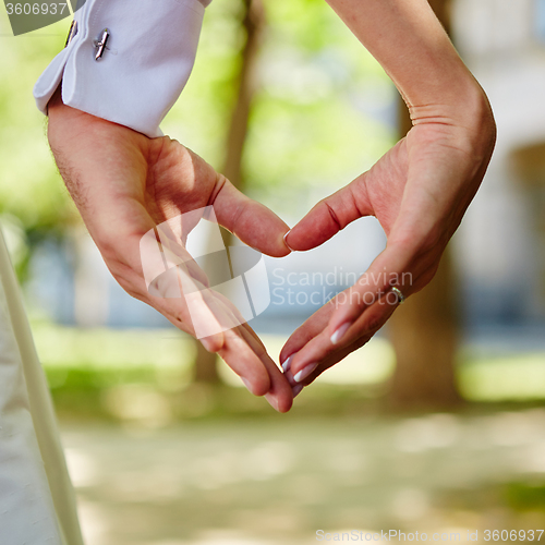 Image of hands bride and groom in shape of heart