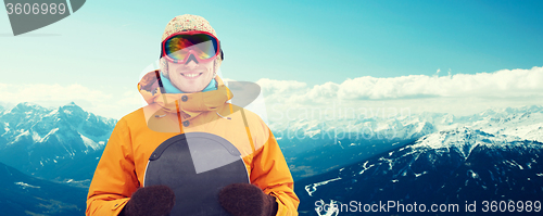 Image of happy young man in ski goggles over mountains