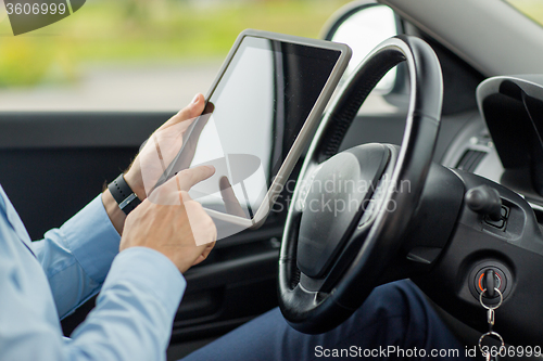 Image of close up of young man with tablet pc driving car