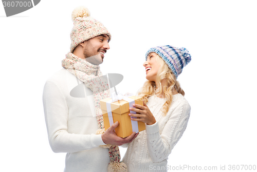 Image of smiling couple in winter clothes with gift box