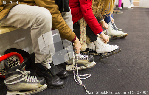 Image of close up of friends wearing skates on skating rink