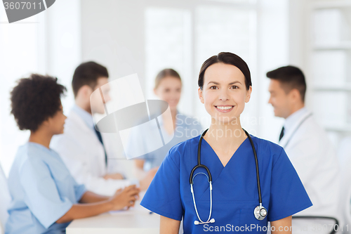 Image of happy doctor over group of medics at hospital