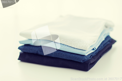 Image of close up of ironed and folded t-shirts on table