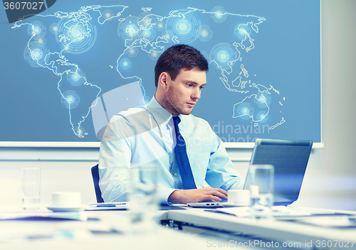 Image of businessman with laptop working in office