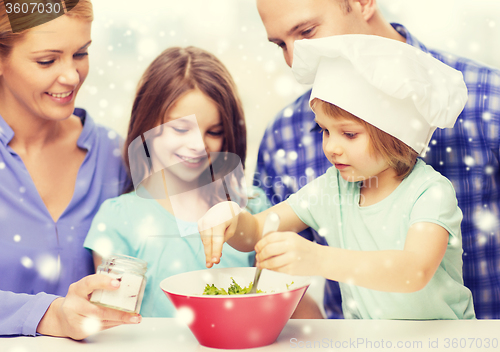 Image of happy family with two kids making salad at home