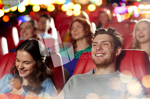 Image of happy friends watching movie in theater