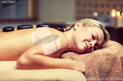 Image of close up of woman having hot stone massage in spa