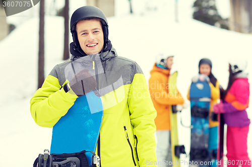 Image of happy friends in helmets with snowboards