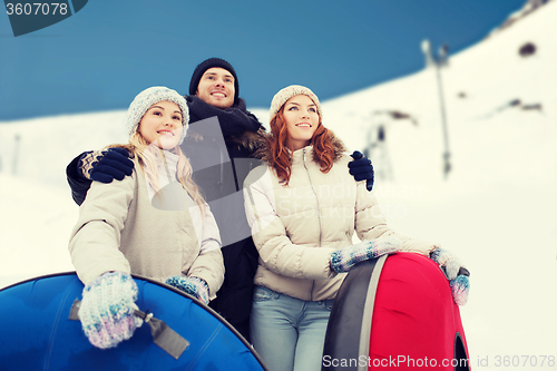 Image of group of smiling friends with snow tubes