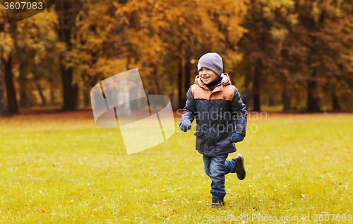 Image of happy little boy running on autumn park field