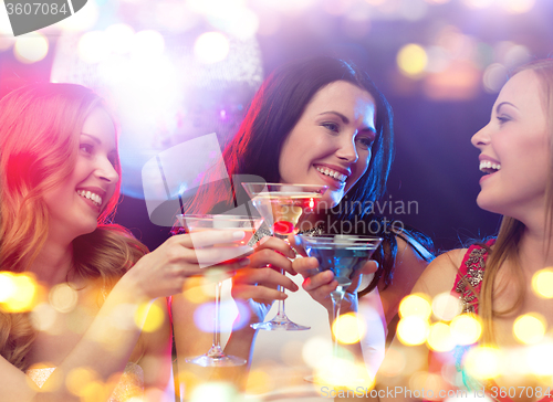 Image of smiling women with cocktails at night club