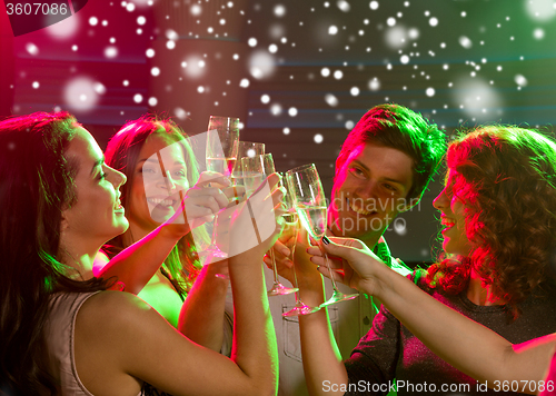 Image of smiling friends with glasses of champagne in club