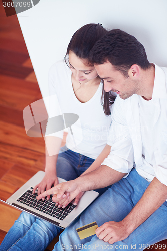 Image of relaxed young couple working on laptop computer at home