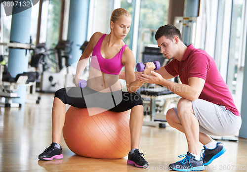 Image of young sporty woman with trainer exercise weights lifting