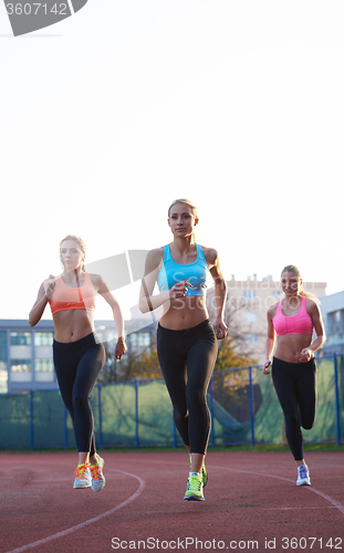 Image of athlete woman group  running on athletics race track