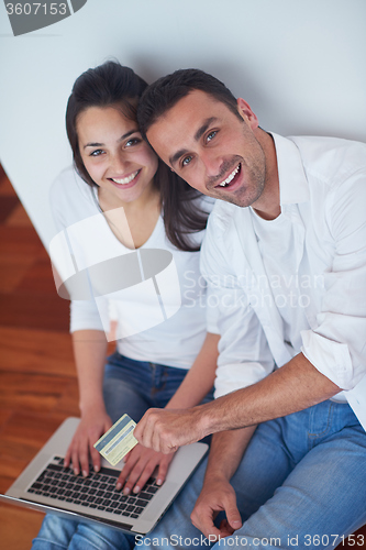 Image of relaxed young couple working on laptop computer at home