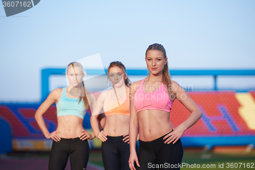 Image of athlete woman group  running on athletics race track
