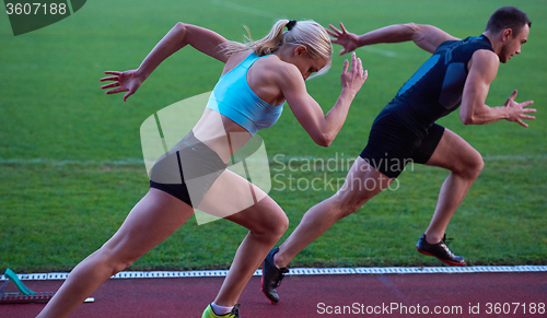 Image of woman group  running on athletics race track from start