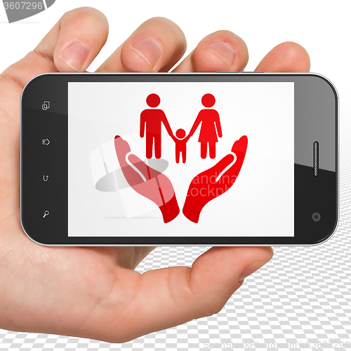 Image of Insurance concept: Hand Holding Smartphone with Family And Palm on display