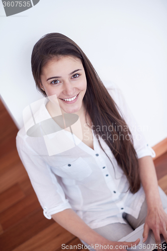 Image of relaxed young woman at home working on laptop computer