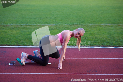 Image of pixelated design of woman  sprinter leaving starting blocks