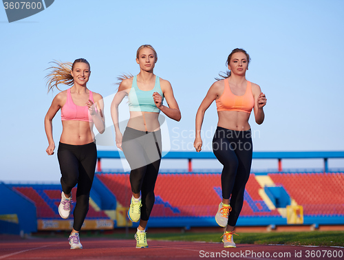 Image of athlete woman group  running on athletics race track