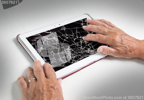 Image of Senior lady with tablet, cracked screen