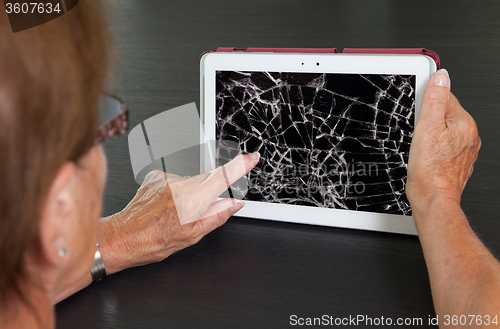 Image of Senior lady with tablet, cracked screen