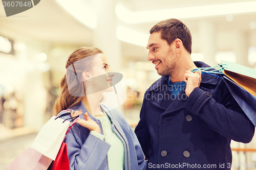 Image of happy young couple with shopping bags in mall