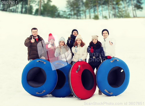 Image of group of smiling friends with snow tubes