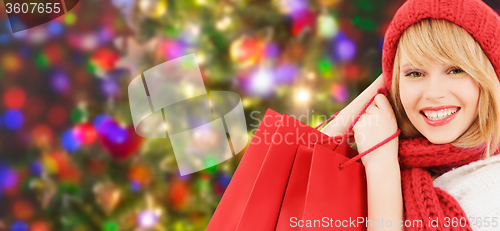 Image of woman in red hat and scarf with shopping bags