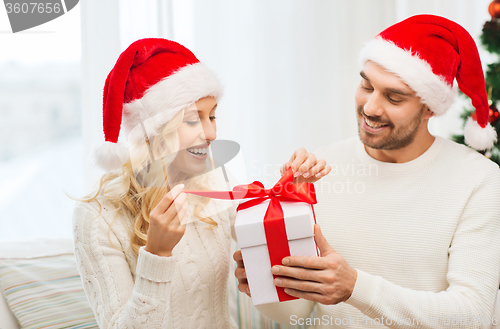 Image of happy couple at home with christmas gift box