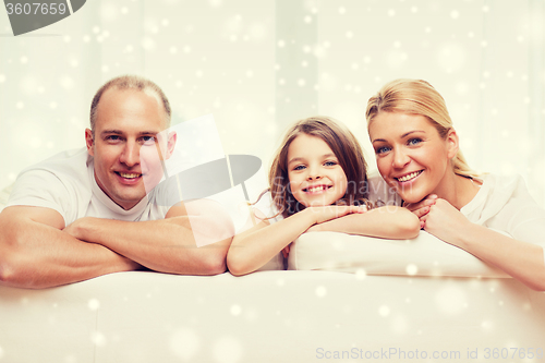 Image of smiling parents and little girl at home