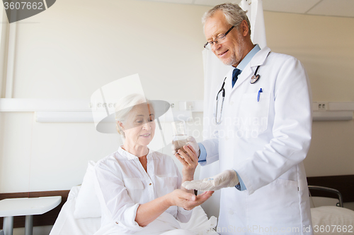 Image of doctor giving medicine to senior woman at hospital