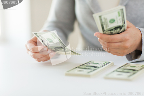 Image of close up of woman hands counting us dollar money