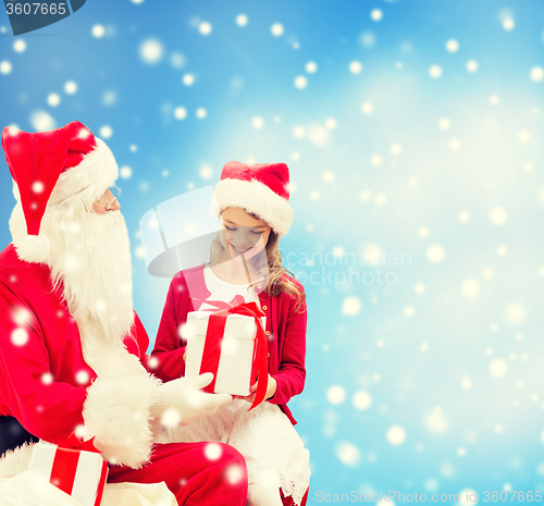 Image of smiling little girl with santa claus and gifts