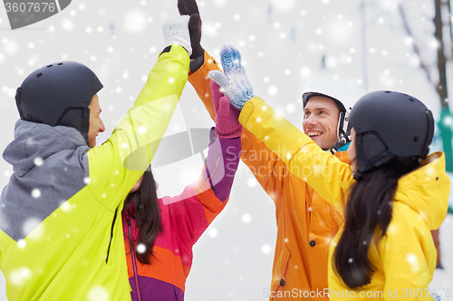 Image of happy friends in helmets making high five