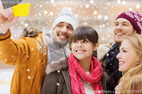 Image of happy friends taking selfie on skating rink