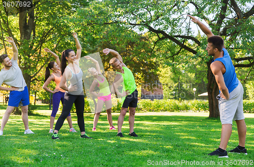 Image of group of friends or sportsmen exercising outdoors