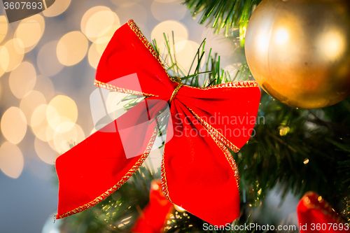 Image of close up of red bow decoration on christmas tree