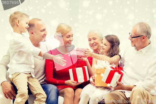 Image of smiling family with gifts at home