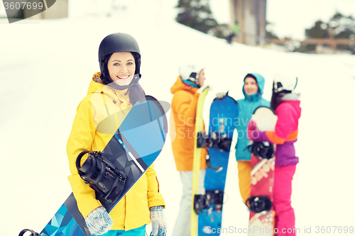 Image of happy friends in helmets with snowboards