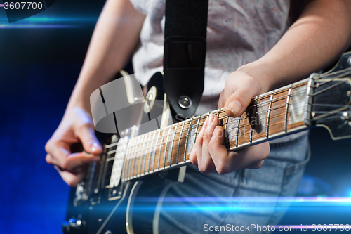 Image of musician playing electric guitar with mediator