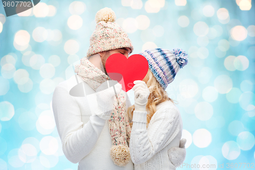 Image of smiling couple in winter clothes with red heart